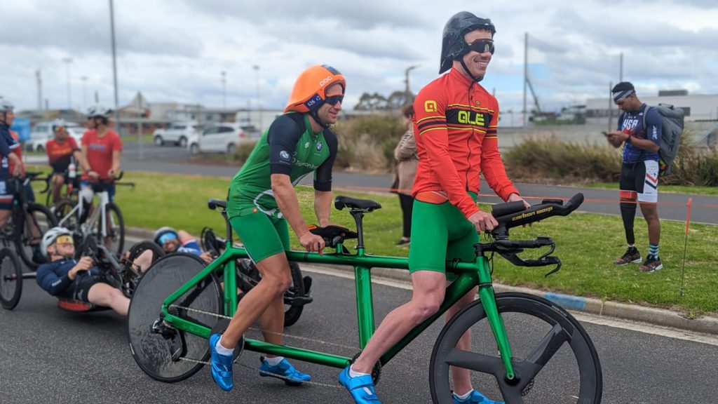 Donnacha McCarthy & Guide Sean Husband stand with their tandem bike at the start of the bike course recce, Devonport 2023.