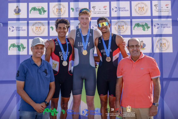 Three racers on the podium at African Junior Cup with coaches