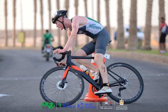 Ryan Lundy in Team Ireland triathlete clothing cycling on black bike