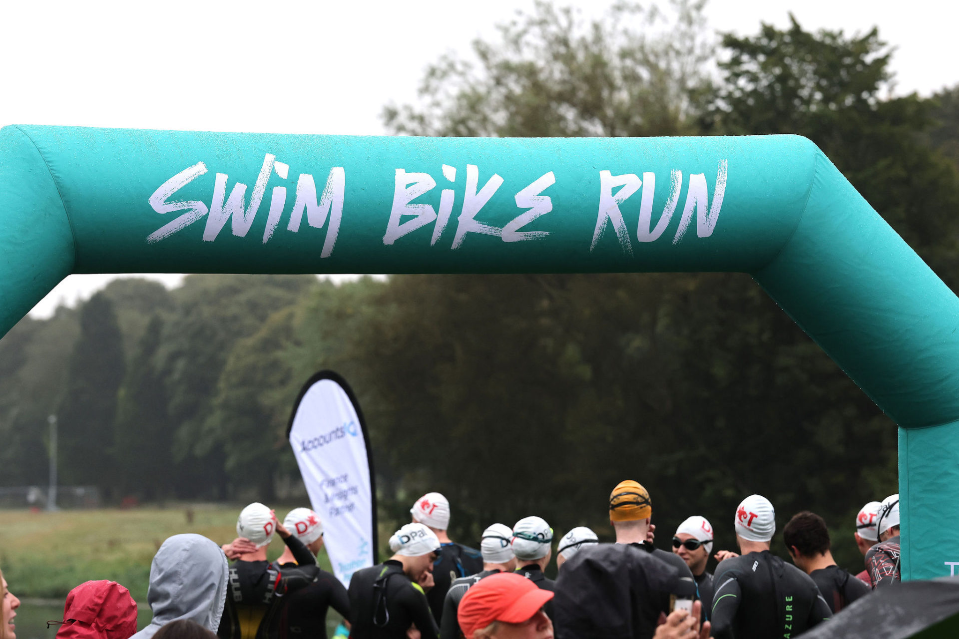 Group of swimmers preparing for race under Triathlon Ireland Arch