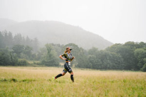 Women running across field in triathlon race