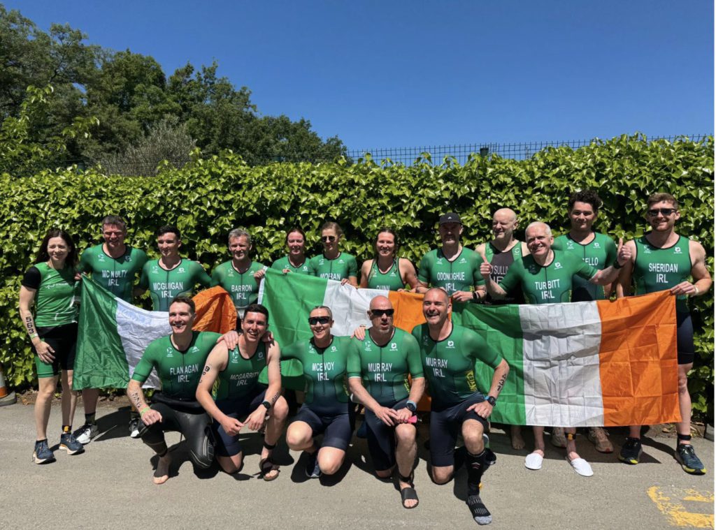 Tri Team Ireland - a group of triathletes posing for a photograph with the Irish flag