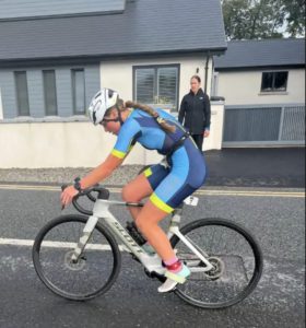 Youth Triathlon Commission Members 2026 - Girl in blue triathlon suit cycling