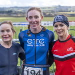 Three female athletes at finish line
