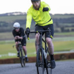 Cyclist going up hill at duathlon fist pumping